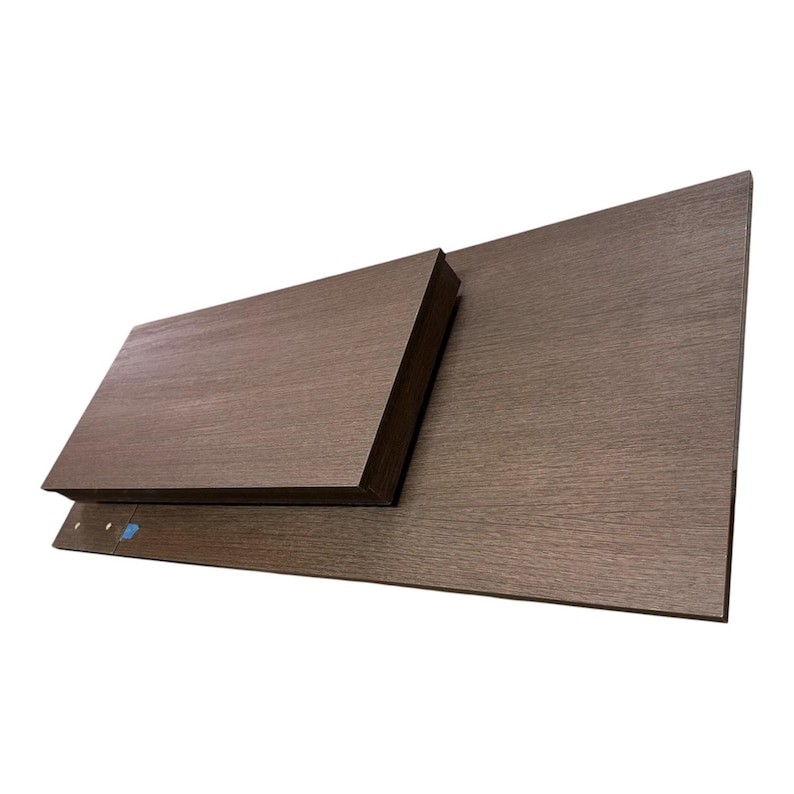 Pu&ograve; includere: Una mensola rettangolare in legno marrone scuro con venature a vista, composta da un ripiano pi&ugrave; piccolo montato su un pannello di base pi&ugrave; grande. La superficie presenta una texture orizzontale e il pannello base include due piccoli fori.