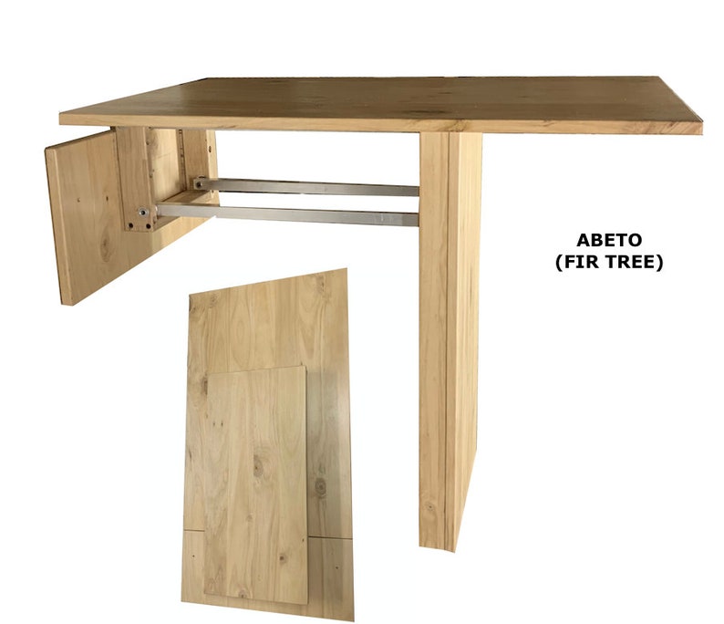 Pu&ograve; includere: Un tavolo in legno chiaro con piano rettangolare e una singola gamba di supporto verticale. Il tavolo presenta un meccanismo di chiusura con binari in metallo argentato e un pannello laterale incernierato. Il testo ABETO (FIR TREE) &egrave; a destra.