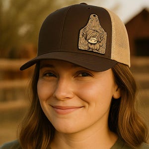 Peut inclure: Une femme porte une casquette de camionneur marron et beige avec un motif d'étiquette de vache. Elle porte également un t-shirt vert avec un motif de scène de désert. L'image comprend le texte "INSTANT DIGITAL DOWNLOAD".