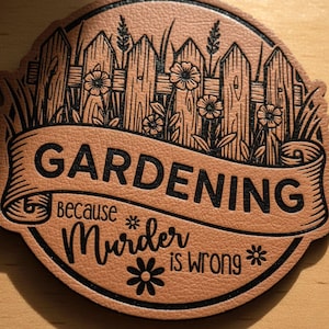 May include: A circular tan leather patch with the words "GARDENING because Murder is wrong" in black. The design includes a fence, flowers, and grass. The image also shows "10 Designs Included" and file formats.