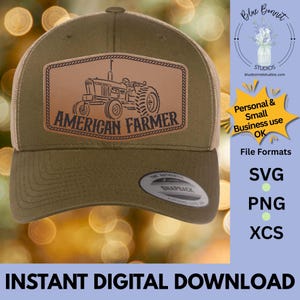 K&ouml;nnte beinhalten: Olivgr&uuml;ne Trucker-Cap mit beigefarbenem Mesh-R&uuml;cken. Auf der Vorderseite befindet sich ein braunes Lederpatch mit einer Traktorgrafik und den Worten "AMERICAN FARMER". Die Kappe hat einen gebogenen Schirm und einen Snapback-Verschluss.