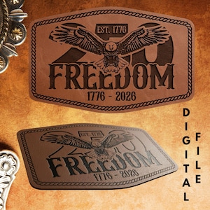 May include: A brown leather-like belt buckle with an eagle design and the word "FREEDOM" in bold letters. The buckle is rectangular with a rope-like border and the text "EST. 1776" and "1776-2026". The words "DIGITAL FILE" are written vertically.