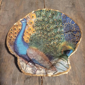May include: A set of three ceramic nesting bowls in shades of blue, green, and white. The bowls feature a speckled glaze and a simple, modern design. The largest bowl measures approximately 6 inches in diameter.