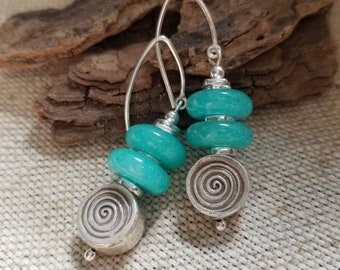May include: Teal and silver dangle earrings with three turquoise beads and a silver spiral design.