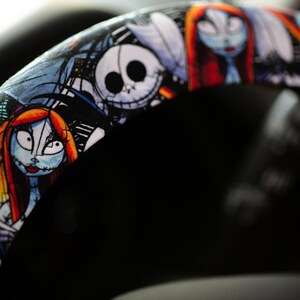 Puede incluir: Una funda para volante negra con un estampado colorido de personajes de la pel&iacute;cula Pesadilla antes de Navidad. Los personajes incluyen a Jack Skellington, Sally y Oogie Boogie.