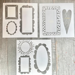 May include: White plastic stencils featuring various frame and shape designs. The stencils include rectangular, oval, and heart shapes, as well as a sunburst design. These stencils are ideal for crafting and DIY projects.