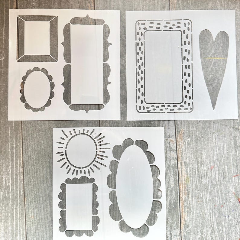 Op de afbeelding: Witte plastic sjablonen met diverse frame- en vormontwerpen. De sjablonen bevatten rechthoekige, ovale en hartvormige vormen, evenals een zonnesterontwerp. Deze sjablonen zijn ideaal voor knutsel- en doe-het-zelfprojecten.