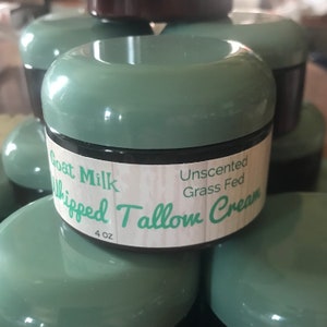 May include: A 4 oz jar of unscented, grass-fed goat milk whipped tallow cream. The jar is green with a white label that reads "Goat Milk Whipped Tallow Cream Unscented Grass Fed".