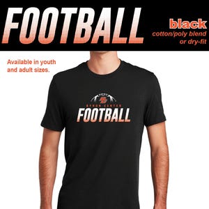 May include: Black t-shirt with the word "FOOTBALL" in white and orange gradient lettering. The shirt features the text "BYRON CENTER FOOTBALL" in a similar style. The shirt is available in youth and adult sizes.
