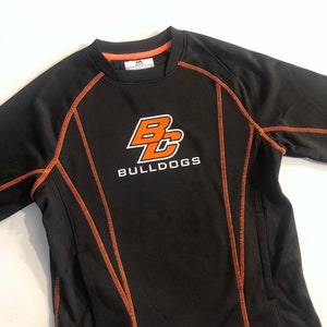 May include: Black long-sleeve shirt with orange stitching and a white logo that says "BC Bulldogs".