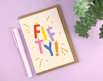 May include: A birthday card with the words "FIFTY!" written in colorful letters that look like candles. The card has a brown envelope and gold foil accents.