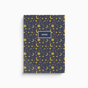 Könnte beinhalten: Ein dunkelblaues Notizbuch mit einem goldenen Sternenhimmelmuster mit Sternen, Monden, Planeten und Kometen. Das Wort "NOTES" ist in Weiß auf dem Einband gedruckt.