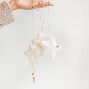 Christmas tree ornaments. Hand-knitted holiday season decorations. Xmas stars. Scandinavian, swedish, nordic minimal hygge home decor.