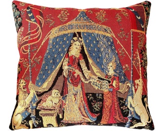Peut inclure: Un coussin en tapisserie représentant une scène médiévale avec une femme en robe rouge et or, une licorne et un lion. La tapisserie est tissée avec des détails complexes et des couleurs vives. Le texte "MONTESQUIEU" est visible en haut de l'oreiller.