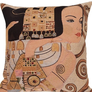 May include: A decorative throw pillow featuring a tapestry design of a woman with a gold headdress and intricate patterns. The background is a muted beige with swirling patterns.