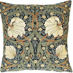 May include: A square throw pillow with a tapestry design featuring stylized white flowers, green leaves, and orange vines on a black background.