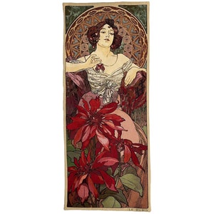 May include: A vintage art nouveau poster featuring a woman in a white dress with red flowers. The woman is surrounded by red flowers and a decorative border.