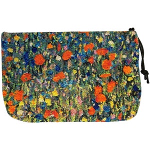 May include: A small, green, blue, orange, and yellow drawstring pouch with a floral pattern. The pouch is made of woven fabric and has a drawstring closure.