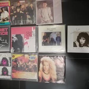 Peut inclure: Une collection d'albums de musique vintage, dont des albums de Dionne Warwick, Jeffrey Osborne, Valentine, Secret Service, Simple Minds, Bee Gees, Starship et Jennifer Rush. Les albums sont de différentes couleurs et présentent différents artistes et titres d'albums.