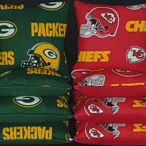 Pode incluir: Quatro sacos de feij&atilde;o verdes com o logotipo dos Green Bay Packers e a palavra "Packers" impressa neles. Quatro sacos de feij&atilde;o vermelhos com o logotipo dos Kansas City Chiefs e a palavra "Chiefs" impressa neles.