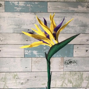 Bird of Paradise felt flower with a 15 inch; flower stem. Flower has 3 full blooms with yellow tepals and purple petals.