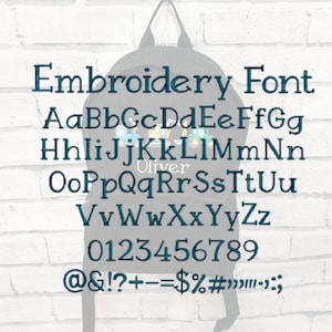 May include: A black backpack with the text "Embroidery Font" and an alphabet, numbers, and symbols in a dark teal color. The name "Oliver" is also displayed on the backpack.