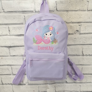 May include: Purple backpack with a mermaid design and the name "Dorothy" embroidered on the front.