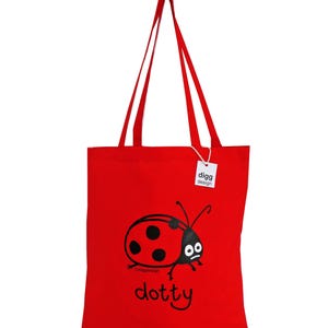 May include: Red tote bag with a black ladybug design and the text "dotty" printed on the front. The bag has two long handles and a white tag with the text "digg design" on it.