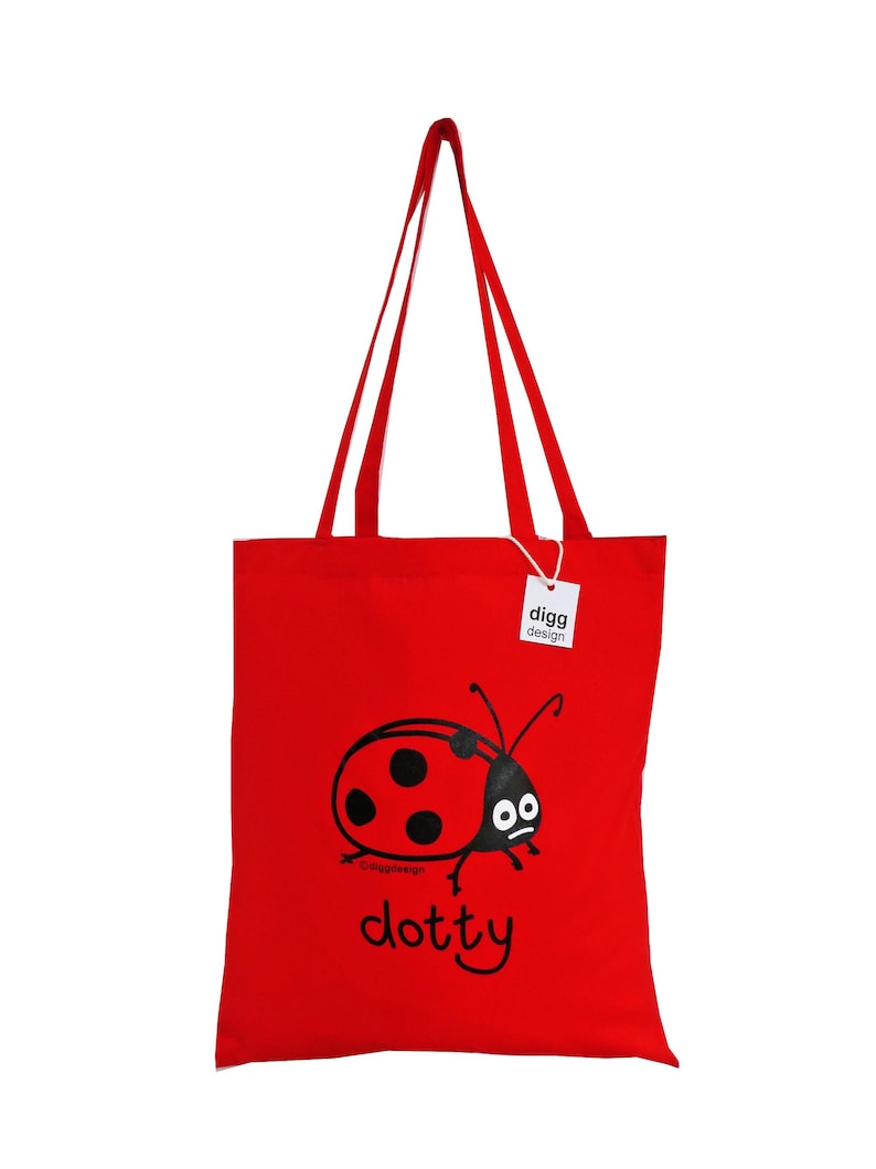 May include: Red tote bag with a black ladybug design and the text "dotty" printed on the front. The bag has two long handles and a white tag with the text "digg design" on it.