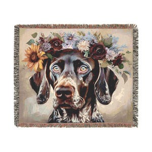 May include: A brown and white German Shorthaired Pointer dog wearing a floral crown of red, white, and purple flowers. The dog is looking directly at the viewer with a serious expression.