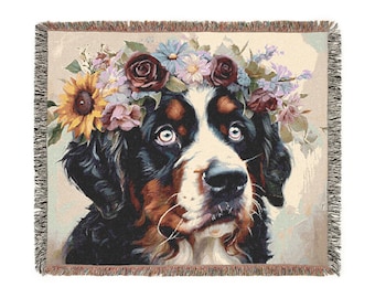 Puede incluir: Un perro de montaña bernés con una corona floral hecha de girasoles, rosas y otras flores. El perro tiene pelo marrón, negro y blanco y está mirando hacia arriba.