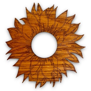 Może przedstawiać: Wycięty z drewna słonecznik z okrągłym otworem w środku. Słonecznik jest jasnobrązowy z ciemnobrązowym obrysem.