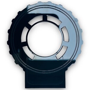 Może przedstawiać: Czarny plastikowy adapter obiektywu do aparatu z okrągłym pierścieniem i prostokątną podstawą.