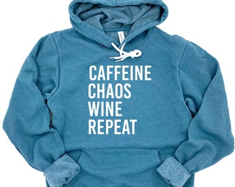 May include: A teal blue hoodie with a white drawstring and the text "CAFFEINE CHAOS WINE REPEAT" printed on the front.