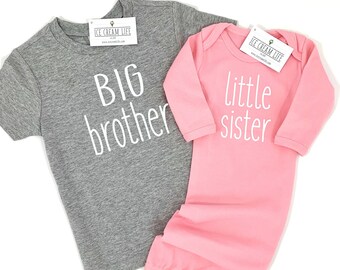May include: Gray short-sleeved shirt with the text "BIG brother" in white. Pink long-sleeved gown with the text "little sister" in white.
