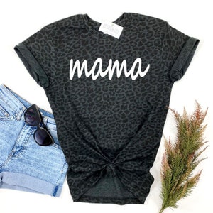 May include: Black t-shirt with a leopard print and the word "mama" in white lettering.