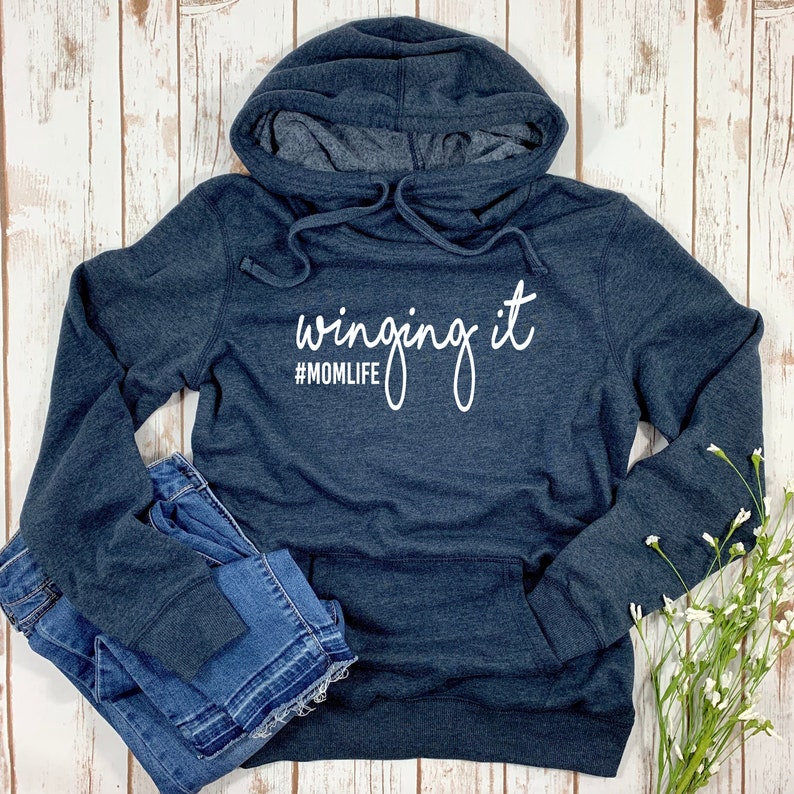 May include: A dark blue hooded sweatshirt with the text "winging it #MOMLIFE" in white.