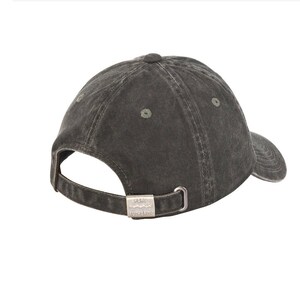 May include: A dark gray cotton baseball cap with a metal buckle closure. The buckle has the words "Puma Authority" embossed on it.
