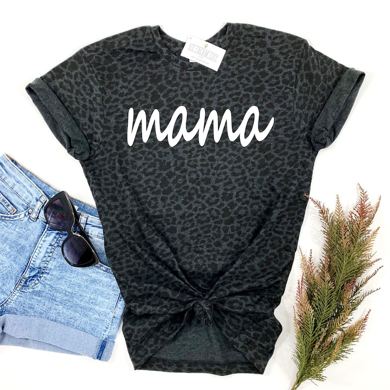 May include: Black t-shirt with a leopard print and the word "mama" in white lettering.