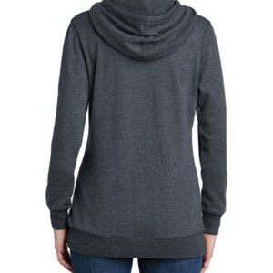 May include: A dark gray hooded sweatshirt with long sleeves and a relaxed fit. The sweatshirt has a drawstring hood and a kangaroo pocket.
