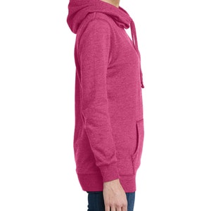 May include: A side view of a magenta hoodie with a drawstring hood and a kangaroo pocket. The long-sleeved sweatshirt is made of a soft, textured material. The hoodie is a solid color and has a relaxed fit.