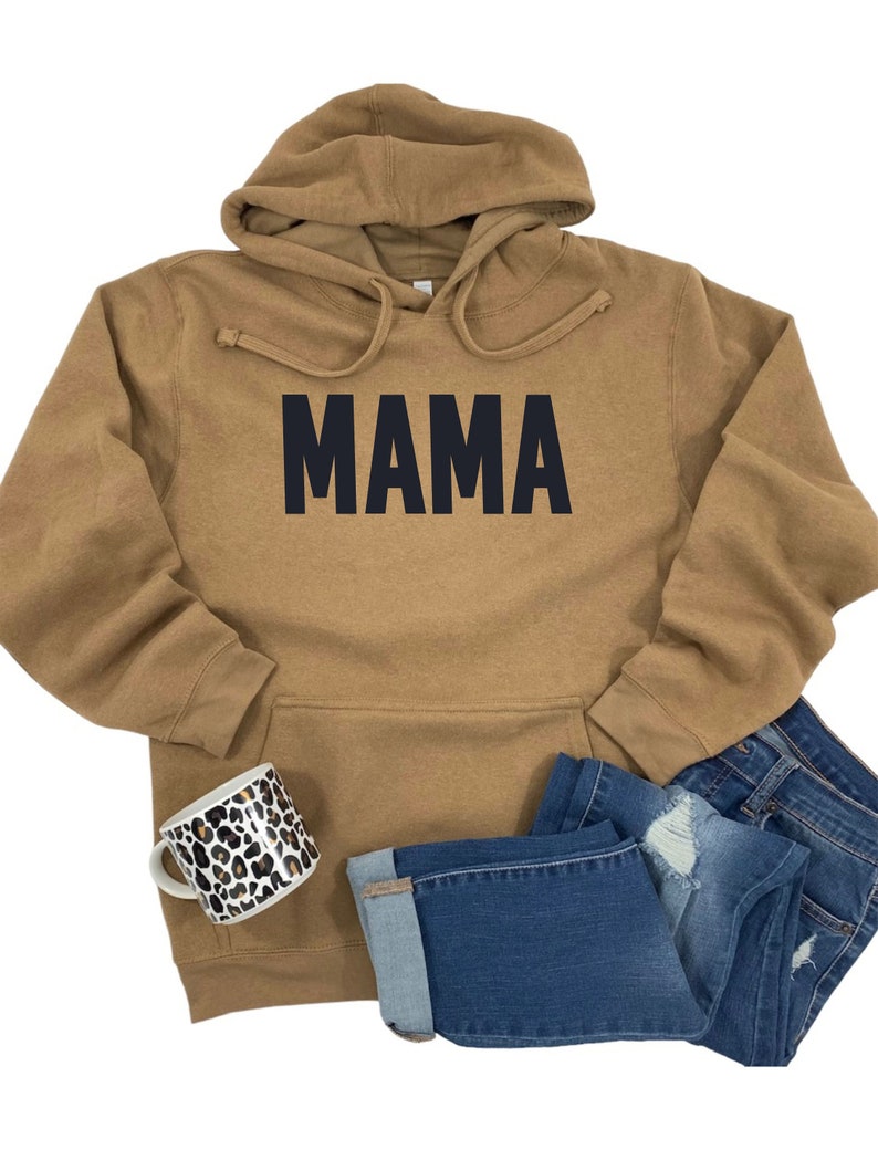 May include: A brown hooded sweatshirt with the word "MAMA" printed in black on the front.