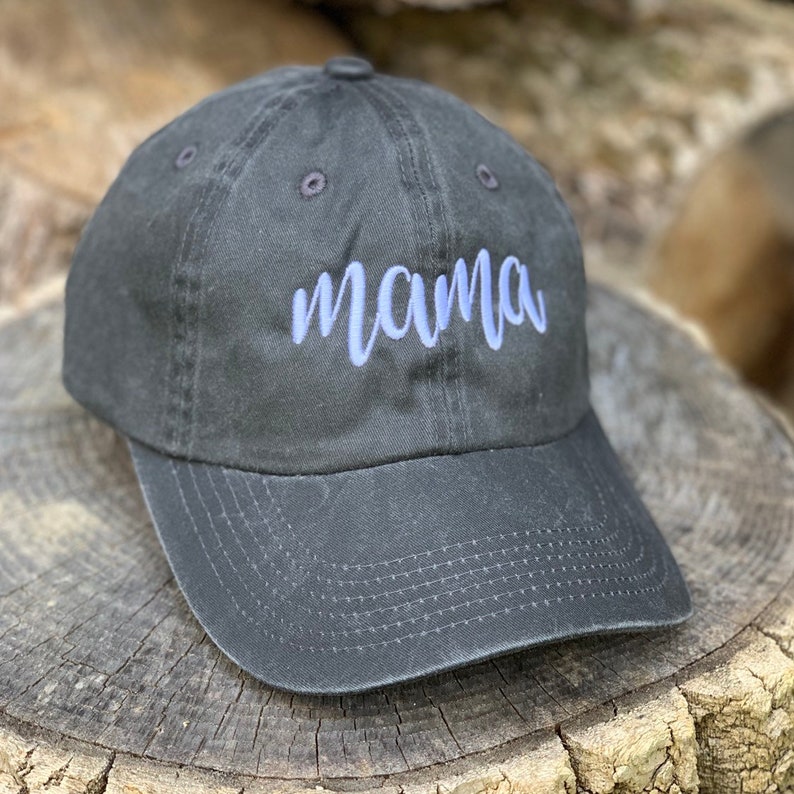 May include: A black baseball cap with a purple embroidered word "mama" on the front.
