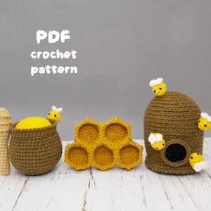 May include: PDF crochet pattern for a beehive, honey pot, and honeycomb. The beehive is brown with a small opening and several yellow and white bees. The honey pot is brown with a yellow honey inside and a small bee on top. The honeycomb is yellow and has six cells.