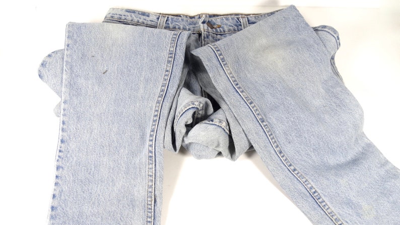 K&ouml;nnte beinhalten: Eine hellblaue Jeanshose, die in der H&auml;lfte gefaltet ist. Die Jeans hat einen klassischen geraden Schnitt und ist aus einem weichen, bequemen Stoff.