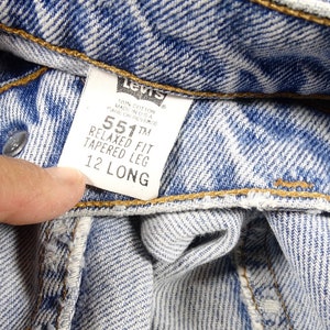 K&ouml;nnte beinhalten: Nahaufnahme eines blauen Jeans-Etiketts von Levi's 551&trade; Relaxed Fit Tapered Leg mit der Gr&ouml;&szlig;e 12 Long.