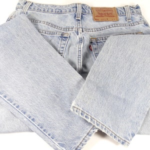 K&ouml;nnte beinhalten: Eine hellblaue Jeanshose, die in der H&auml;lfte gefaltet ist. Die Jeans hat ein braunes Leder-Etikett auf der R&uuml;ckseite mit dem Text "Levi's&reg; Original  Quality  Guaranteed  501&reg;  Made in the USA  W 32 L 34".