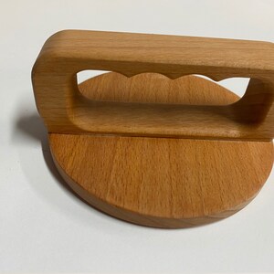 May include: A wooden lid with a handle. The handle has a cutout design and is attached to the lid with a rounded base.