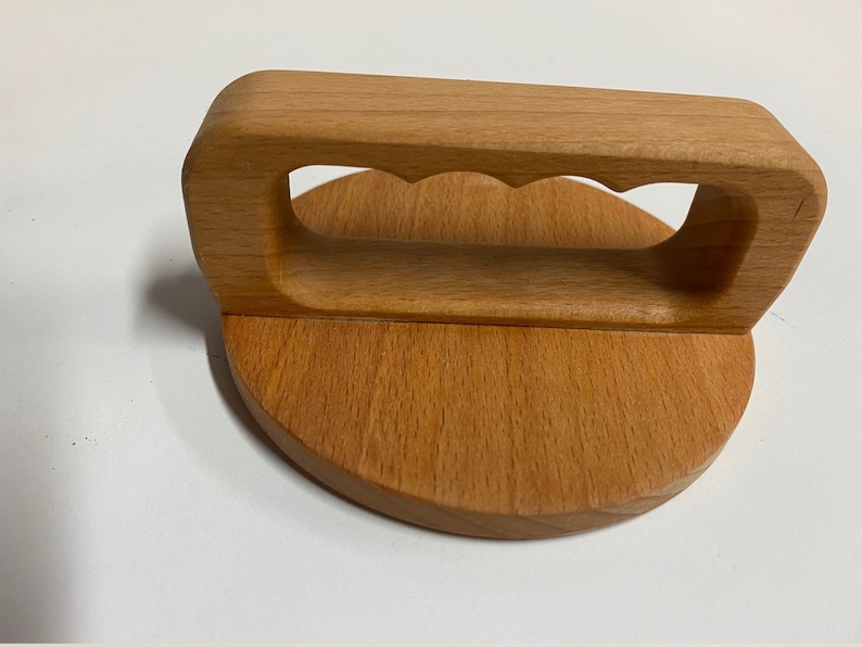 May include: A wooden lid with a handle. The handle has a cutout design and is attached to the lid with a rounded base.