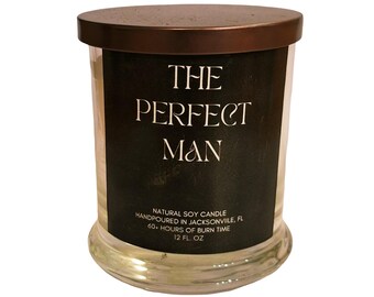 May include: A clear glass candle jar with a dark brown lid. The label reads "THE PERFECT MAN" in white text on a black background. The candle is a natural soy candle, hand-poured in Jacksonville, FL, with a 60-hour burn time and 12 fl oz.